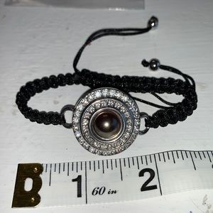 Adjustable braided black cord bracelet with one interchangeable snaps. NWOT